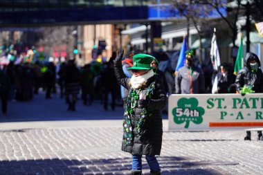 Milwaukee, Wisconsin ABD - 12 Mart 2022: Shamrock kulübü üyeleri Aziz Patrick günü için giyindiler ve geçit töreni için pankart taşıdılar.