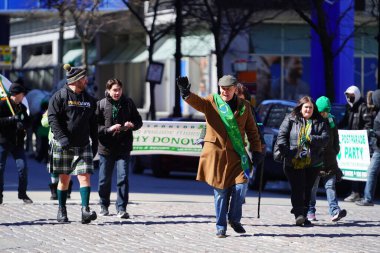 Milwaukee, Wisconsin ABD - 12 Mart 2022: Shamrock kulübü üyeleri Aziz Patrick günü için giyindiler ve geçit töreni için pankart taşıdılar.