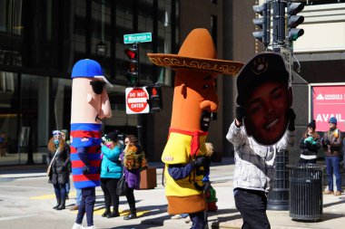 Milwaukee, Wisconsin ABD - 12 Mart 2022 Milwaukee Brewers Sosis maskotu yarışçıları St. Patrick Günü geçit töreninde yürüdüler.