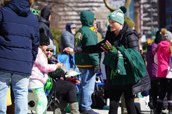 Milwaukee, Wisconsin ABD - 12 Mart 2022 Seyirciler 2022 St. Patrick Günü yürüyüşünü kaldırımlardan izledi. 