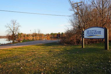 Köydeki eski bir binanın önündeki göl ve su tabelası..