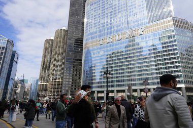 Chicago, Illinois ABD - 16 Mart 2024: St. Patrick renk ve kostüm giymiş izleyiciler durdu ve Chicago Nehri 'nin Trump binasının önünde duran yeşil renkli boyayı izledi