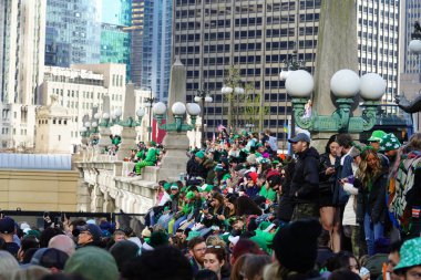 Chicago, Illinois ABD - 16 Mart 2024: St. Patrick renk ve kostüm giymiş izleyiciler durdu ve Chicago Nehri 'nin Trump binasının önünde duran yeşil renkli boyayı izledi