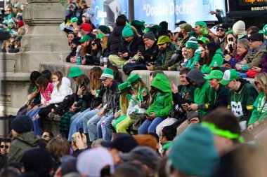 Chicago, Illinois ABD - 16 Mart 2024: St. Patrick renk ve kostüm giymiş izleyiciler durdu ve Chicago Nehri 'nin Trump binasının önünde duran yeşil renkli boyayı izledi