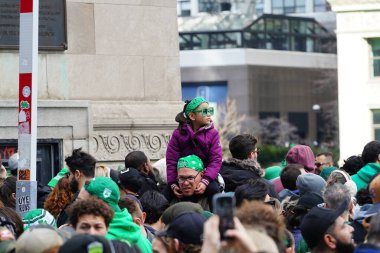 Chicago, Illinois ABD - 16 Mart 2024: St. Patrick renk ve kostüm giymiş izleyiciler durdu ve Chicago Nehri 'nin Trump binasının önünde duran yeşil renkli boyayı izledi