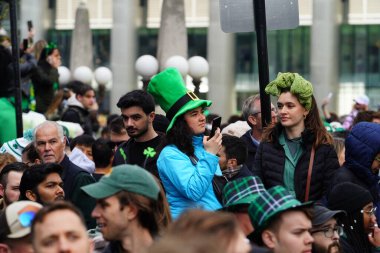 Chicago, Illinois ABD - 16 Mart 2024: St. Patrick renk ve kostüm giymiş izleyiciler durdu ve Chicago Nehri 'nin Trump binasının önünde duran yeşil renkli boyayı izledi