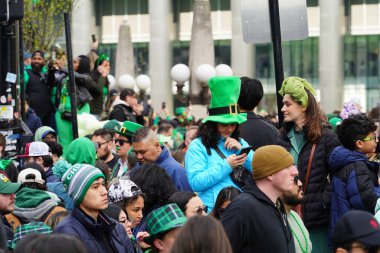 Chicago, Illinois ABD - 16 Mart 2024: St. Patrick renk ve kostüm giymiş izleyiciler durdu ve Chicago Nehri 'nin Trump binasının önünde duran yeşil renkli boyayı izledi