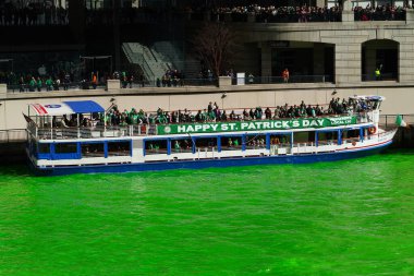Chicago, Illinois ABD - 16 Mart 2024: Seyirciler su boyama sırasında Chicago Nehri üzerinde tekne turlarına çıktılar.