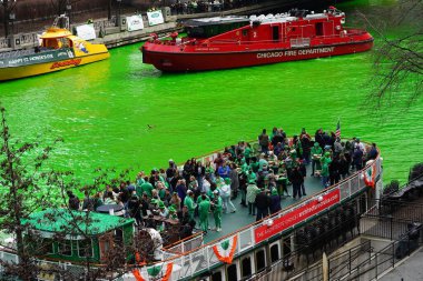 Chicago, Illinois ABD - 16 Mart 2024: Seyirciler su boyama sırasında Chicago Nehri üzerinde tekne turlarına çıktılar.