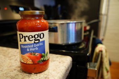 Fond du Lac, Wisconsin USA - 4 Nisan 2024: Prego kavrulmuş bir kavanoz sarımsak ve Herb spagetti sosu tezgahta kullanılmayı bekliyor.