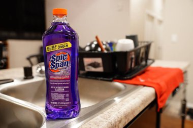 Fond du Lac, Wisconsin USA - 6 Nisan 2024: Mor bir şişe Lavanta COVID öldüren antibakteriyel temizleyici mutfak tezgahında oturuyor.