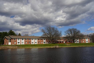 Mauston, Wisconsin ABD - 13 Nisan 2024: Bulutlu bir günde Brick 'in göl kenarındaki apartmanlarının manzarası.