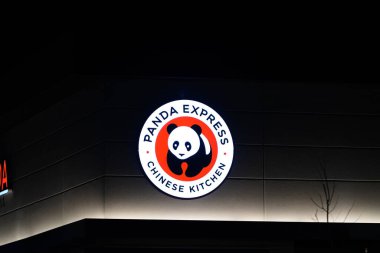 Oshkosh, Wisconsin ABD - 14 Nisan 2024: Panda Ekspres logosu restoran binasının yanında gece parlıyor.