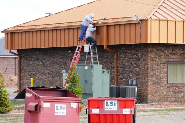 ウィスコンシン州ヒューストン 2024年4月12日 建物に手作業の労働構造をしている男性 ストック写真
