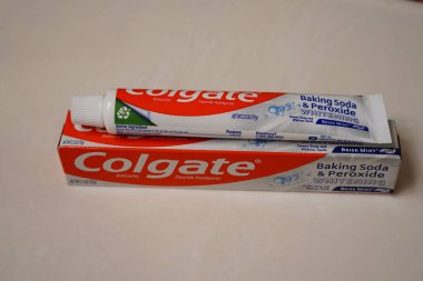 Fond du Lac, Wisconsin USA - 21 Nisan 2024: Banyoda duran bir kutu Colgate Kabartma Gazozu ve Peroksit Beyazlatıcı Diş macunu.
