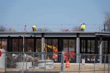 Oshkosh, Wisconsin ABD - 26 Nisan 2024: Toplumdaki binalar üzerinde inşaat yapan erkekler.