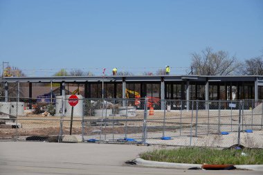 Oshkosh, Wisconsin ABD - 26 Nisan 2024: Toplumdaki binalar üzerinde inşaat yapan erkekler.