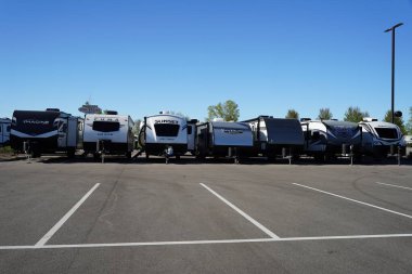 Oshkosh, Wisconsin ABD - 12 Mayıs 2024: Bir çok farklı kampçı ve karavan markası gelecek yaz tatili için satılmak üzere bir galeride duruyor