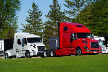 Fond du Lac, Wisconsin USA - May 9th, 2024: Red and White semi trucks sit parked on the dealership lot.