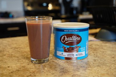 Fond du Lac, Wisconsin USA - 19 Mayıs 2024: Bir kutu Nestle Ovaltine zengin çikolatalı süt ve bir bardak süt mutfak tezgahında duruyor.