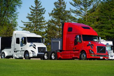 Fond du Lac, Wisconsin USA - May 9th, 2024: Red and White semi trucks sit parked on the dealership lot.