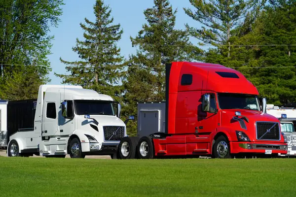 stock image Fond du Lac, Wisconsin USA - May 9th, 2024: Red and White semi trucks sit parked on the dealership lot.