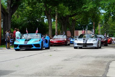 Appleton, Wisconsin ABD - 7 Haziran 2024: Birçok toplum üyesi, şehir merkezinde yürüyen spor arabalarla bayrak günü geçit törenini izlemek için izleyici olmaya geldi..