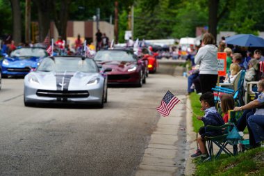 Appleton, Wisconsin ABD - 7 Haziran 2024: Birçok toplum üyesi, şehir merkezinde yürüyen spor arabalarla bayrak günü geçit törenini izlemek için izleyici olmaya geldi..