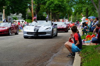 Appleton, Wisconsin ABD - 7 Haziran 2024: Birçok toplum üyesi, şehir merkezinde yürüyen spor arabalarla bayrak günü geçit törenini izlemek için izleyici olmaya geldi..