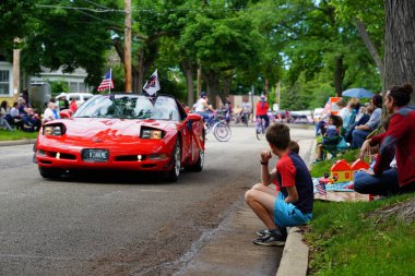 Appleton, Wisconsin ABD - 7 Haziran 2024: Birçok toplum üyesi, şehir merkezinde yürüyen spor arabalarla bayrak günü geçit törenini izlemek için izleyici olmaya geldi..