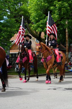 Appleton, Wisconsin ABD - 14 Haziran 2024: Bayrak Günü Geçidi boyunca Amerikan Bayraklarını taşıyan kadınlar.