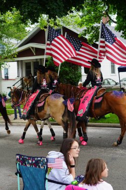 Appleton, Wisconsin ABD - 14 Haziran 2024: Bayrak Günü Geçidi boyunca Amerikan Bayraklarını taşıyan kadınlar.