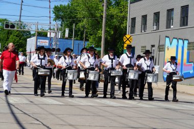 Appleton, Wisconsin USA - June 12th, 2024: Adult males and females in a marching band marched down the streets during a parade. clipart