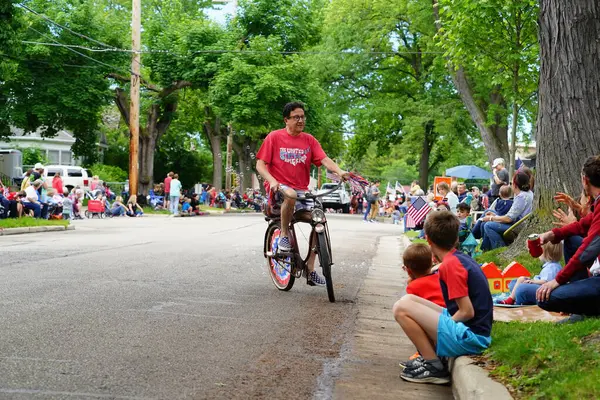 Appleton, Wisconsin ABD - 7 Haziran 2024: Birçok toplum üyesi, şehir merkezinde motosikletlilerin yürüdüğü Bayrak Günü geçit törenini izlemek için izleyici olmaya geldi..
