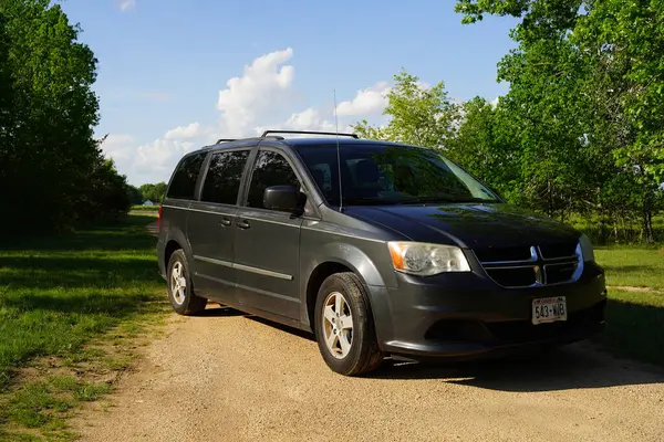 New Lisbon, Wisconsin, ABD - 15 Mayıs 2024: Dark Gray 2012 Dodge Grand Caravan bir orman tarafından park edilmiş..