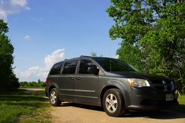 New Lisbon, Wisconsin, ABD - 15 Mayıs 2024: Dark Gray 2012 Dodge Grand Caravan bir orman tarafından park edilmiş..