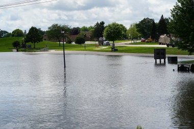 Waupun, Wisconsin ABD - 23 Haziran 2024: Sokaklar ve halk şiddetli sağanak yağmurlardan dolayı sular altında kaldı.