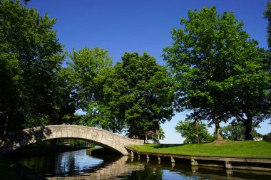 Taştan köprü nehir üzerinde bir parktan geçiyor. 