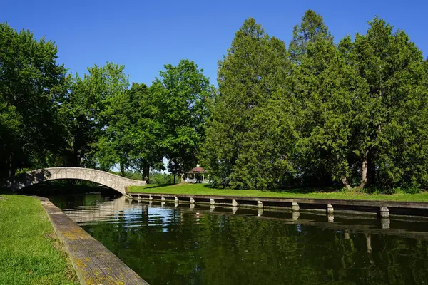 stock image Stone bridge arches over a river through a community park 