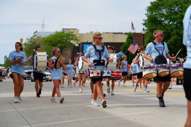 Sheboygan, Wisconsin USA - July 4th, 2024: High school male and female drumline group participated in the Freedom Fest parade. clipart