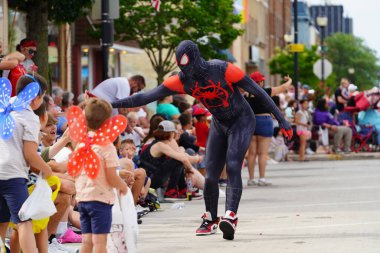 Sheboygan, Wisconsin ABD - 4 Temmuz 2024: Örümcek Adam kostümlü insanlar Özgürlük Festivali geçit töreninde yürüdüler ve çocuklarla etkileşime geçtiler.