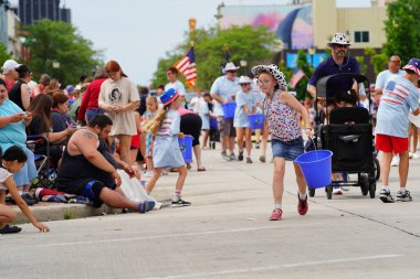 Sheboygan, Wisconsin ABD - 4 Temmuz 2024: Özgürlük Festivali katılımcıları sokaklardaki çocuklara şeker dağıttı.