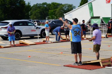 Fond du Lac, Wisconsin USA - 20 Temmuz 2024: Erkekler ve dişiler bir toplulukta mısır çuvalı atma oyunu oynuyorlar.