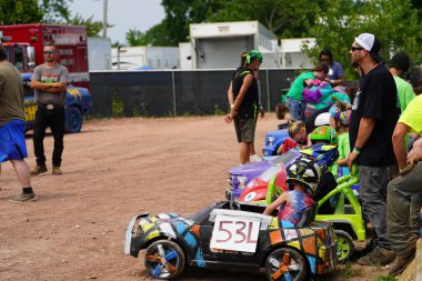 Fond du Lac, Wisconsin USA - July 21st, 2024: Power wheels with kids driven in Hollywood Motorsports Entertainment annual paws for the cause at Fond du Lac county fair. clipart