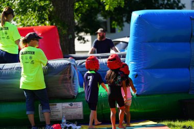 Fond du Lac, Wisconsin USA - 6 Ağustos 2024: Aile üyeleri ve çocuklar engelli parkurda şişme şişme evlerde eğlendiler.