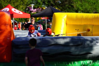 Fond du Lac, Wisconsin USA - 6 Ağustos 2024: Aile üyeleri ve çocuklar engelli parkurda şişme şişme evlerde eğlendiler.