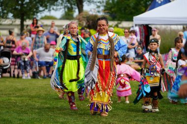 Neenah, Wisconsin ABD - 14 Eylül 2024: Yerli erkekler, kadınlar ve çocuklar yıllık Powwow etkinliğinde birlikte dans ettiler.