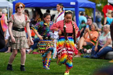 Neenah, Wisconsin ABD - 14 Eylül 2024: Yerli erkekler, kadınlar ve çocuklar yıllık Powwow etkinliğinde birlikte dans ettiler.