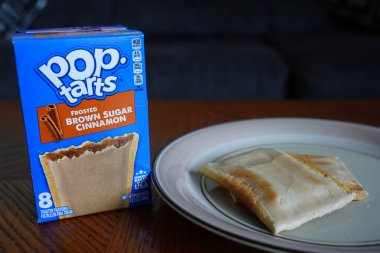 Fond du Lac, Wisconsin USA - 2 Ekim 2024: Donmuş kahverengi tarçınlı tart kutusu kahve masasında oturuyor.