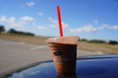 Fond du Lac, Wisconsin USA - Plastik bir fincan Karuba Cold Brew Kahve ve Frappes dışarıda oturuyor.